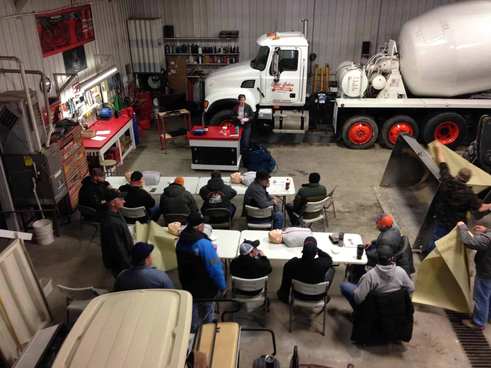 Workforce training at West-Hodson manufacturing plant featuring a large concrete mixer truck and industrial tools.