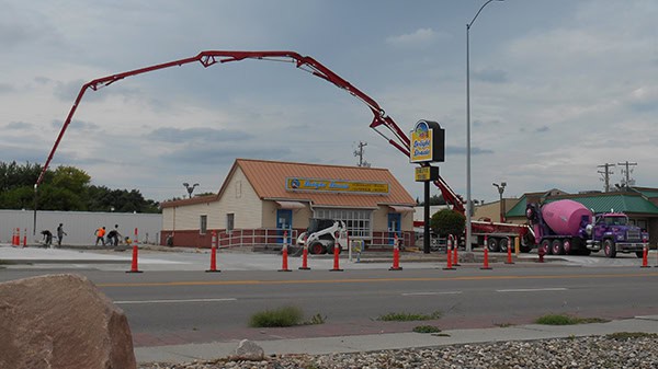 A concrete pump truck pouring concrete at a construction site.