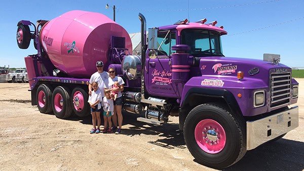 Pink cement mixer truck with children and family, vibrant and fun vehicle for events.