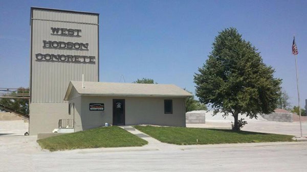 Historic West Hodson school in Oklahoma with sign and greenery.
