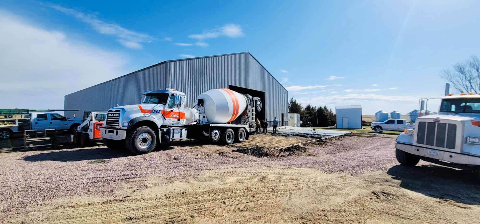 Modern industrial building with trucks and construction activity outdoors.
